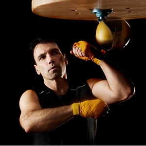 Balazs Boxer with yellow handwraps hitting speed bag 